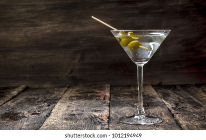 Martini with olives. On a wooden background.