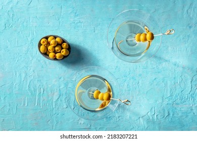 Martini, Two Glasses With Spicy Olives, On A Blue Background. Alcoholic Cocktails, Overhead Flat Lay Shot