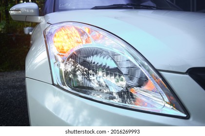 Maruti Suzuki Swift Dzire White car headlamp corner straight view with turn indicator turned on
