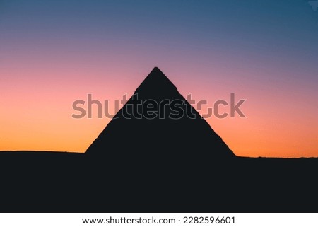 Marvel at the stunning Giza pyramids at sunset - silhouetted against a colorful sky. This photo captures the timeless majesty of one of the world's most iconic landmarks