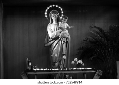 Mary And Baby Jesus Statue With Votive Candles. Religion Catholic Icon. Black And White.