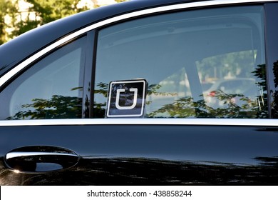 MARYLAND, USA - JUNE 17, 2016: A black car with an Uber sticker in the rear passenger window. Uber Technologies Inc. is an American multinational online transportation network company.