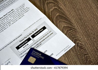 MARYLAND, USA - MAY 9, 2016: A Chase Sapphire Preferred credit card laying next to a BGE gas and electric bill. The Sapphire Preferred card is a travel rewards credit card provided by Chase bank.
