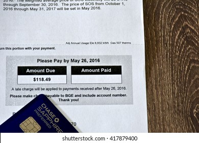 MARYLAND, USA - MAY 9, 2016: A Chase Sapphire Preferred credit card laying next to a BGE gas and electric bill. The Sapphire Preferred card is a travel rewards credit card provided by Chase bank.