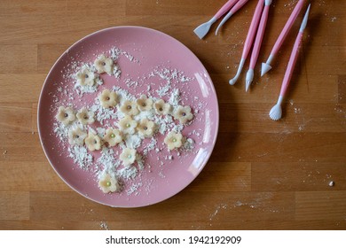 Marzipan Flowers And Sugar On A Pink Plate On A Wooden Table, With Pink Fondant Cake Decorating Tools. 