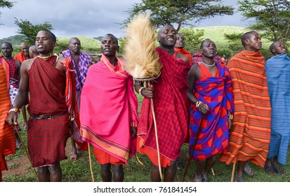 Masai Mara, Kenya - 12/04/2015 : Masai Tribe Traditional Dance And Song. The Tribe Leader Is Holding A Fury Hat On A Stick, Symbol Of His Leadership