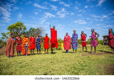 Masai Mara, Kenya »; August 2018: A Group Of Masais Explaining The Masai Tradiones To A Group Of Tourists And One Of Them Jumping