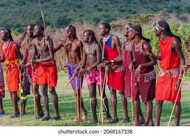 MASAI MARA, KENYA - September 2019: A Group Of Men In A National Clothes Of Masai Mara Tribe Singing Together Together 