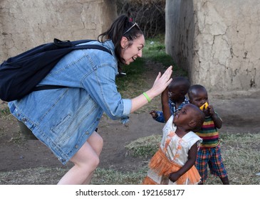 Masai Mara, NA, Kenya - August 15 2018: Tourist Clashes His Hand With Several Unknown Children From A Masai Tribe In Kenya