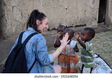 Masai Mara, NA, Kenya - August 15 2018: Tourist Clashes His Hand With Several Unknown Children From A Masai Tribe In Kenya