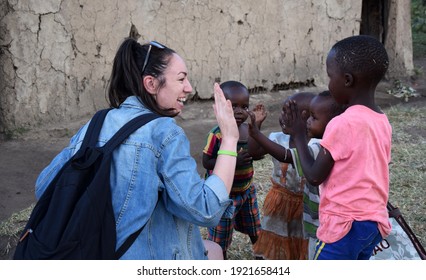 Masai Mara, NA, Kenya - August 15 2018: Tourist Clashes His Hand With Several Unknown Children From A Masai Tribe In Kenya