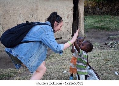 Masai Mara, NA, Kenya - August 15 2018: Tourist Clashes His Hand With Several Unknown Children From A Masai Tribe In Kenya