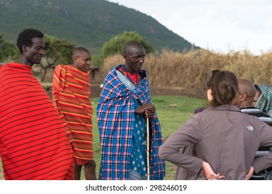 MASAI MARA NATIONAL PARK, KENYA - JUNE 28, 2014. Warriors From Masai Tribe Meeting Tourists In Masai Village 