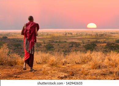 Masai Warrior Looks Out Over Serengeti At Sunset