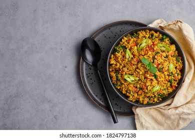 Masala Egg Bhurji Or Muttai Podimas In Black Bowl On Gray Concrete Table Top. Anda Bhurji Is Indian Cuisine Scrambled Eggs Dish With Spices. Asian Food And Meal.