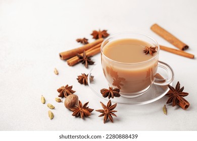 Masala tea or karak chai in a glass cup with cardamom, star anise and cinnamon. 