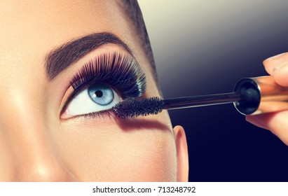 Mascara Applying. Long Lashes closeup. Mascara Brush. Eyelashes extensions. Makeup for Blue Eyes. Eye Make up Apply, Eyebrows shaping. Beautiful woman eyes make-up