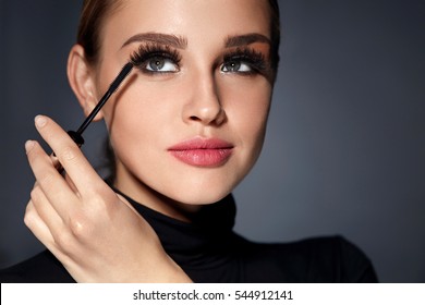 Mascara. Closeup Of Beautiful Young Woman Face With Beauty Makeup, Fresh Soft Skin And Long Black Thick Eyelashes Applying Mascara With Cosmetic Brush. Make-up And Cosmetics Concept. High Resolution