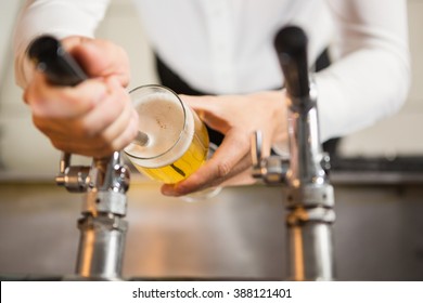 Masculine Hands Pouring A Pint In A Pub