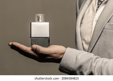 Masculine perfume. Male holding up bottle of perfume. Man perfume, fragrance. Perfume or cologne bottle and perfumery, cosmetics, scent cologne bottle, male holding cologne. - Shutterstock ID 2084584825