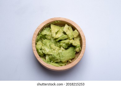 Mashed Avocado In A Wooden Cup On White Background