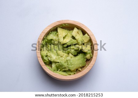 mashed avocado in a wooden cup on white background Foto stock © 