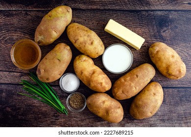 Mashed Potato Ingredients on a Rustic Wood Table: Russet potatoes, cream, butter, and other ingredients for mashed potato side dish