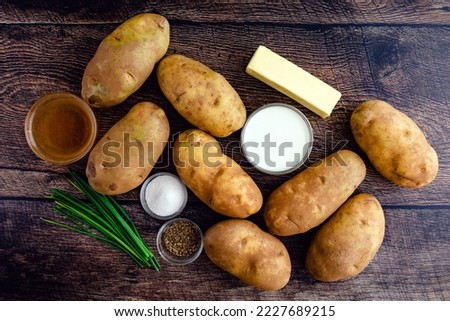 Mashed Potato Ingredients on a Rustic Wood Table: Russet potatoes, cream, butter, and other ingredients for mashed potato side dish
