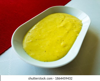 Mashed Potatoes With Black Pepper, White Pepper And Nutmeg On A White Tablecloth And Red Table Runner