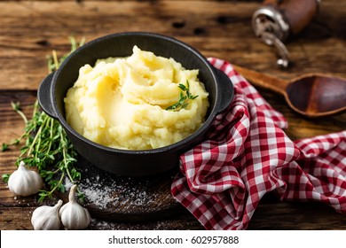 Mashed potatoes, boiled puree in cast iron pot on dark wooden rustic background - Shutterstock ID 602957888