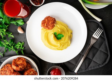 Mashed potatoes with cutlets, tomato juice and herbs on a dark background. High quality photo - Shutterstock ID 2076209284