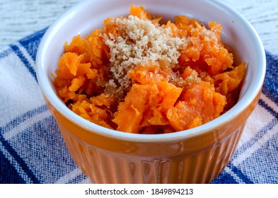 Mashed Sweet Potato In Orange Bowl With Blue Napkin.  Overhead View With Horizontal Composition.