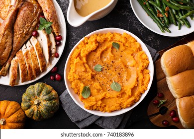 Mashed Sweet Potatoes With Butter And Cinnamon On Thanksgiving Table With Turkey And Green Beans Overhead Shot