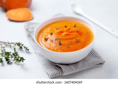 mashed sweet potatoes in a wooden bowl on a light background - Shutterstock ID 1607404369