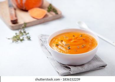 mashed sweet potatoes in a wooden bowl on a light background - Shutterstock ID 1836152239