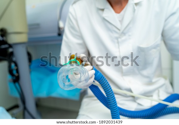 Mask for anesthesia in operating room.\
Unrecognizible doctor holds mask in hands.\
Closeup.