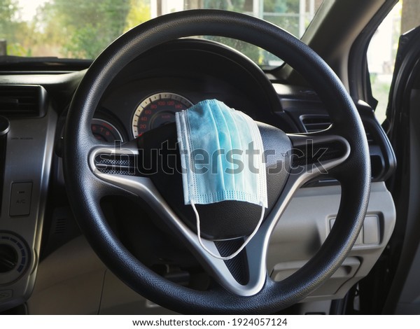 The mask in the car placed on the steering\
wheel, life concept during COVID\
19