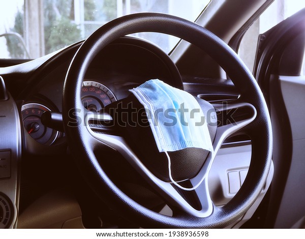The mask in the car placed on the steering\
wheel, life concept during COVID\
19