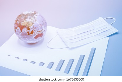 Mask And The Earth Globe Placed On The Graph Showing The Increasing Number Of Infected Patients From All Over The World During Crisis Covid-19. Business, Economy, Healthcare Concept