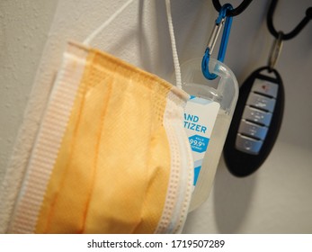 Mask Hand Sanitizer And Car Key Hanging On Key Rack Selective Focus