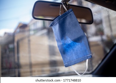 Mask Hanging From The Rear View Mirror On The Dash