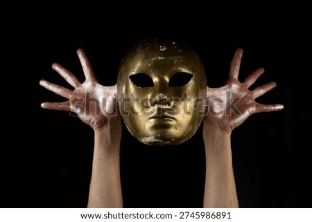 Mask hiding identity with dramatic hands gesture. Mask symbolizing anonymity and secrecy concept. Mask expressing dual personality and inner conflict. Mask representing hidden truth and mystery.