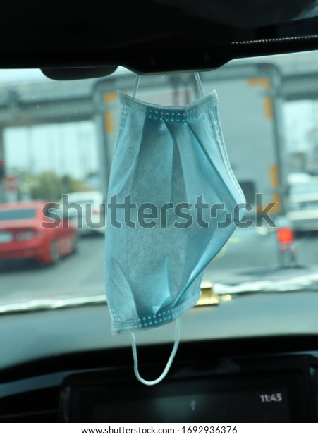 The mask\
is hung on the rear view mirror in the\
car.