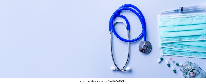 Mask With Pills, Stethoscope, Syringe Medical Supply Objects Isolated On Blue Background, Top View, Flat Lay, Overhead Shot, Virus Protection Concept.