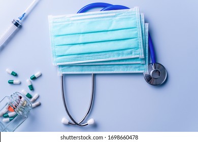 Mask With Pills, Stethoscope, Syringe Medical Supply Objects Isolated On Blue Background, Top View, Flat Lay, Overhead Shot, Virus Protection Concept.