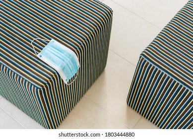 Mask Resting On A Striped Stool In A Hotel Room In Majorca. New Habits In Responsible Tourism. Abstract And Geometric Background