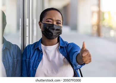 Masked african-american woman on a city street. Teenage girl patient, copy space. Epidemic, pandemic, corona virus protection, healthy lifestyle, people concept - Powered by Shutterstock