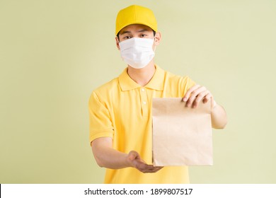 The Masked Asian Delivery Man Was Holding The Paper Bag
