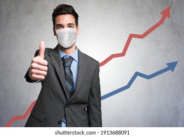 Masked Business Man Giving Thumbs Up In Front Of A Positive Diagram During Covid Coronavirus Pandemic