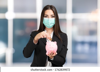 Masked Businesswoman Putting Money In A Piggy Bank, Coronavirus Savings And Investments Concept